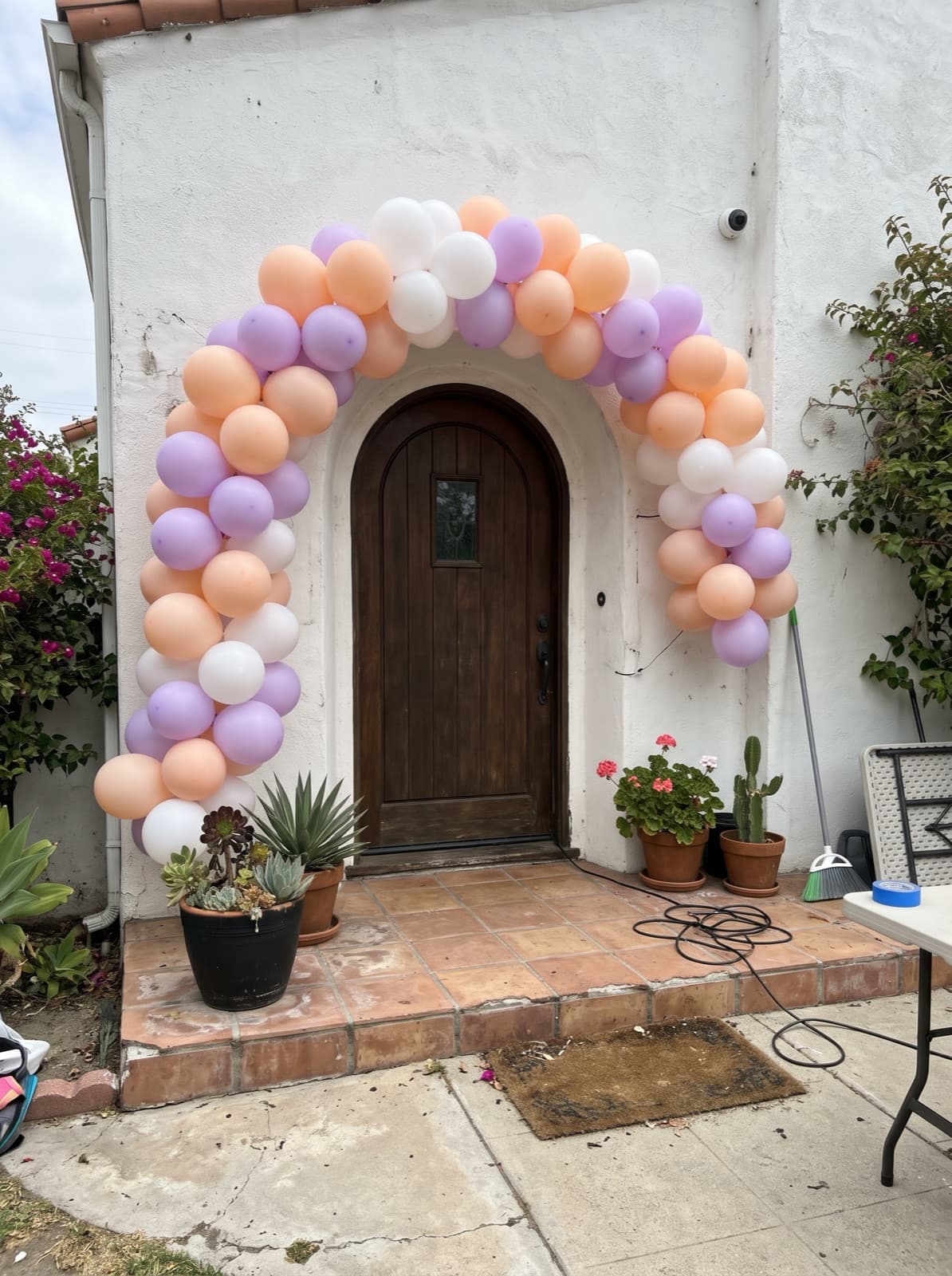 Peach, lilac and white arch around a rounded stucco doorway
