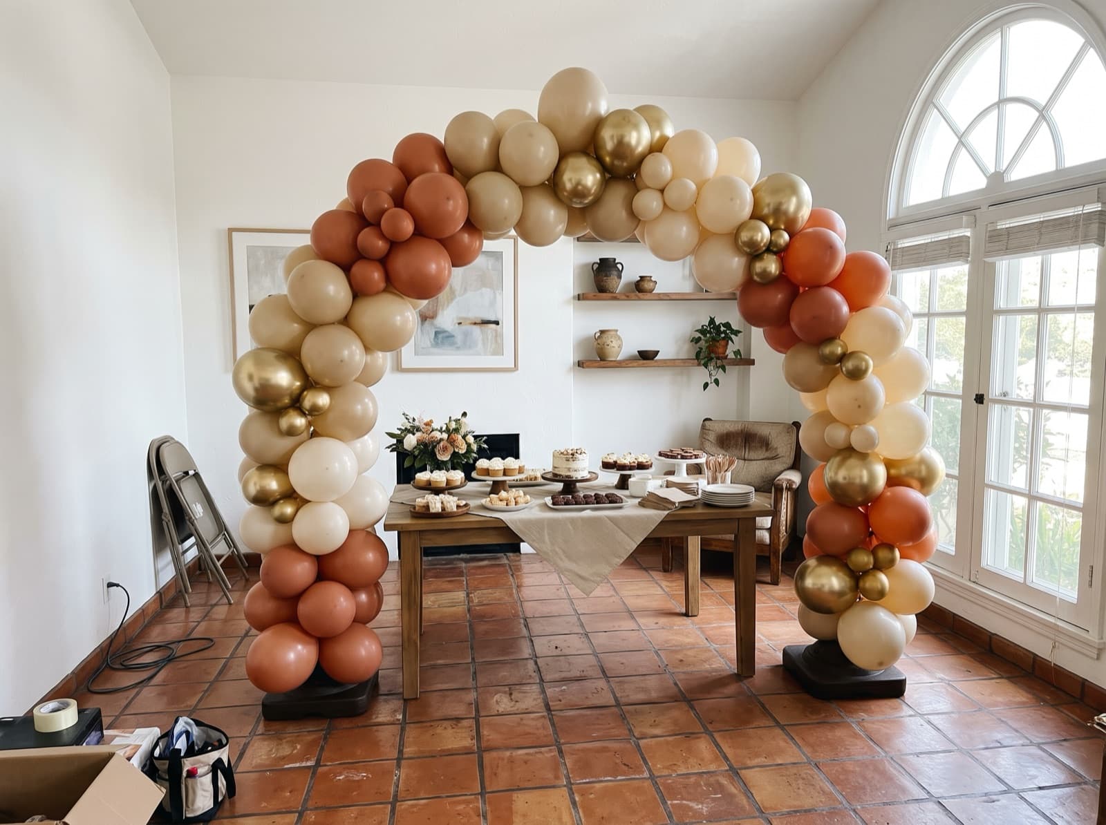 Organic balloon arch in terracotta, sand and cream over a dessert table at a Los Angeles birthday party