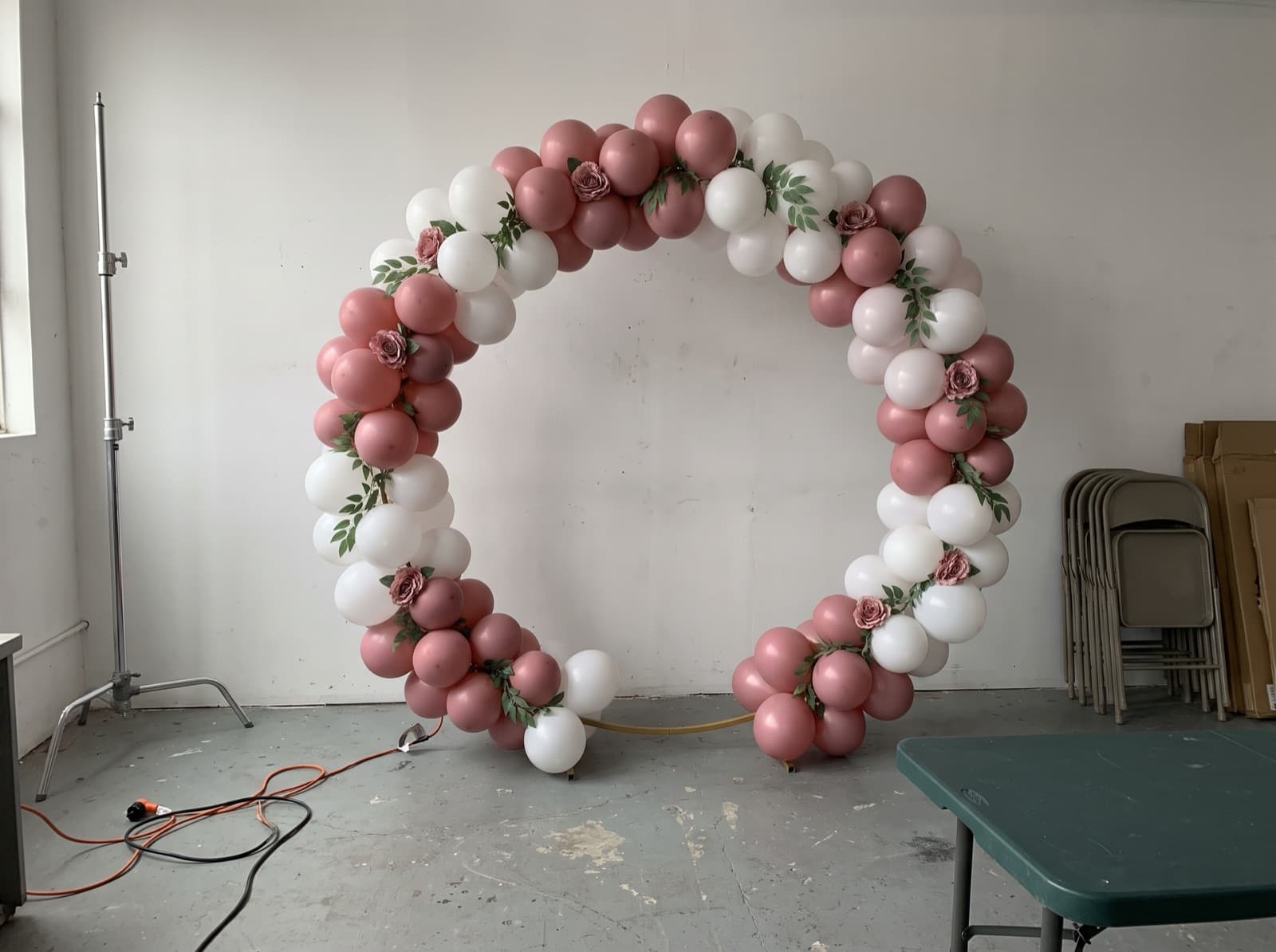 Dusty rose circle arch ready for photos in a rental studio