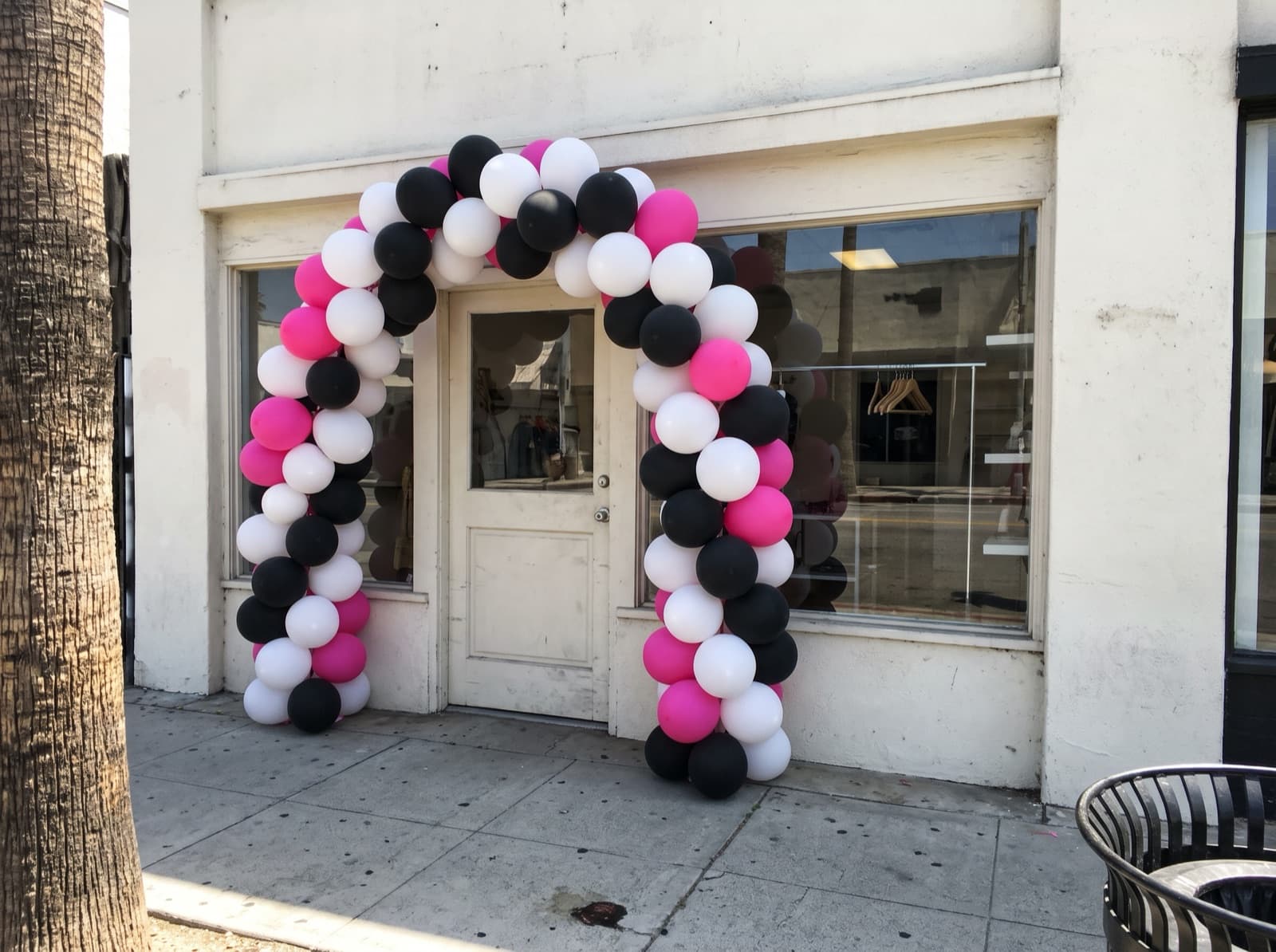 Hot pink, black and white arch framing a shop door